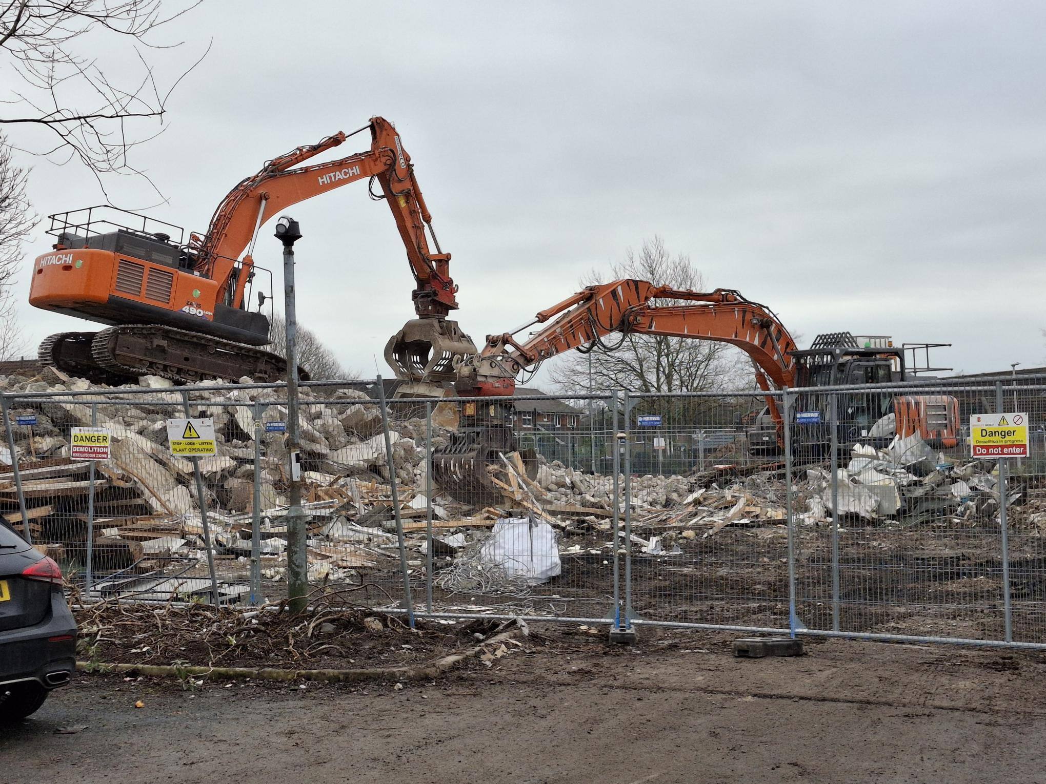 Two diggers break down the rubble