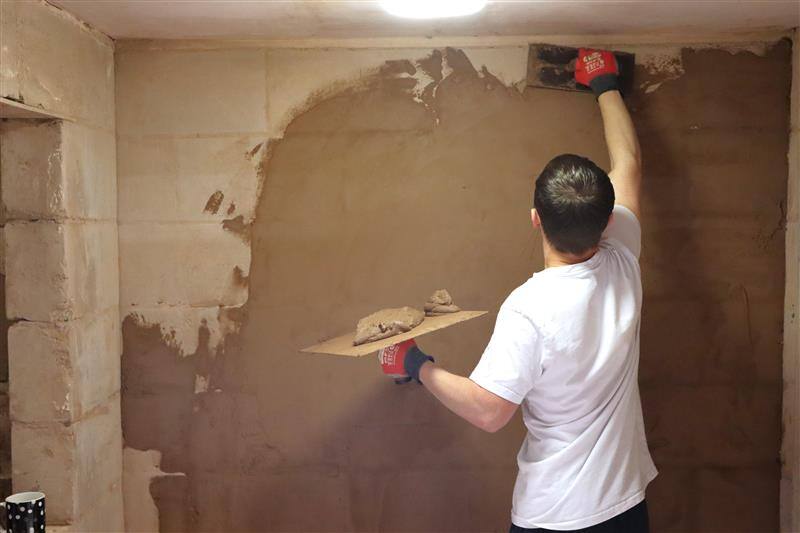 Picture 1 - A participant tries his hand at plastering during a hands-on session